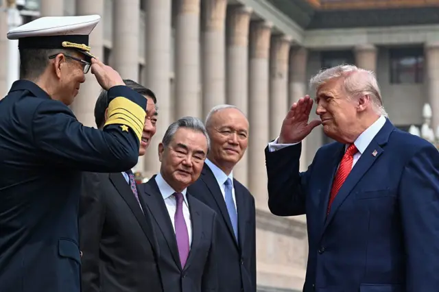 5月14日，美国总统特朗普（右）在北京人民大会堂举行的欢迎仪式上，向中国国防部长董军（左）行礼。
